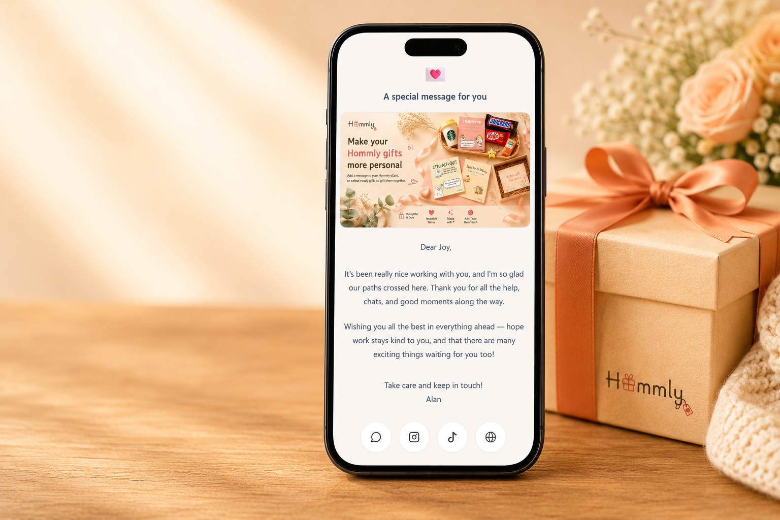 Phone showing a Hommly eCard beside a Hommly gift — the experience recipients open after scanning
